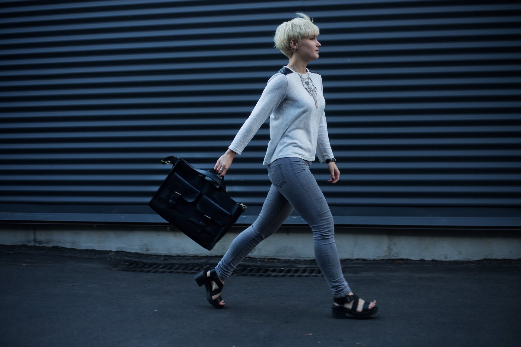 Woman Holding Black Leather Handbag Walking on The Street