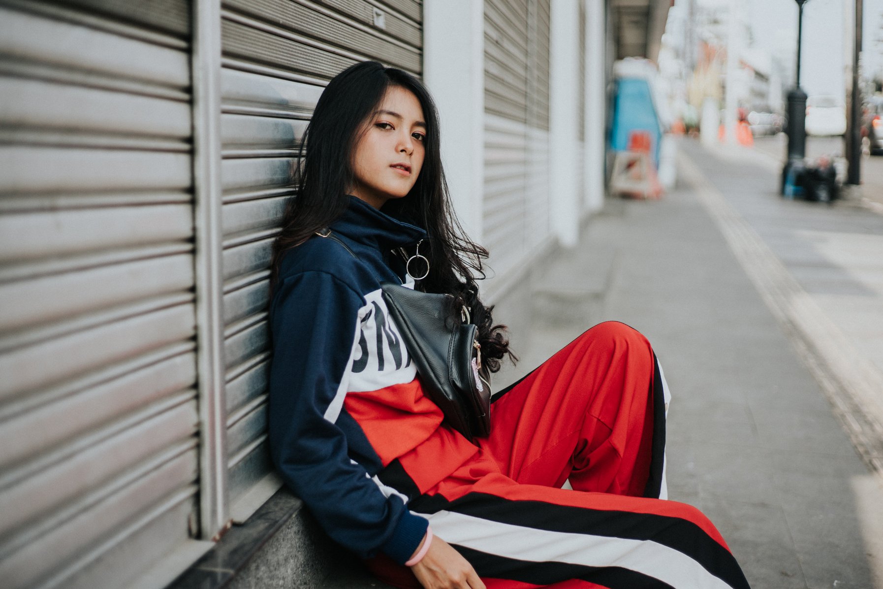 Woman in Blue and Red Jacket Sitting on Gray Concrete Stairs